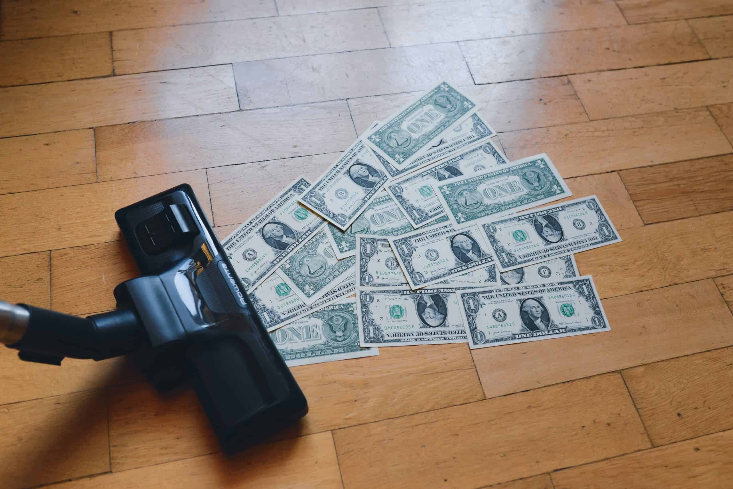 Image of a vacuum cleaner sucking up money