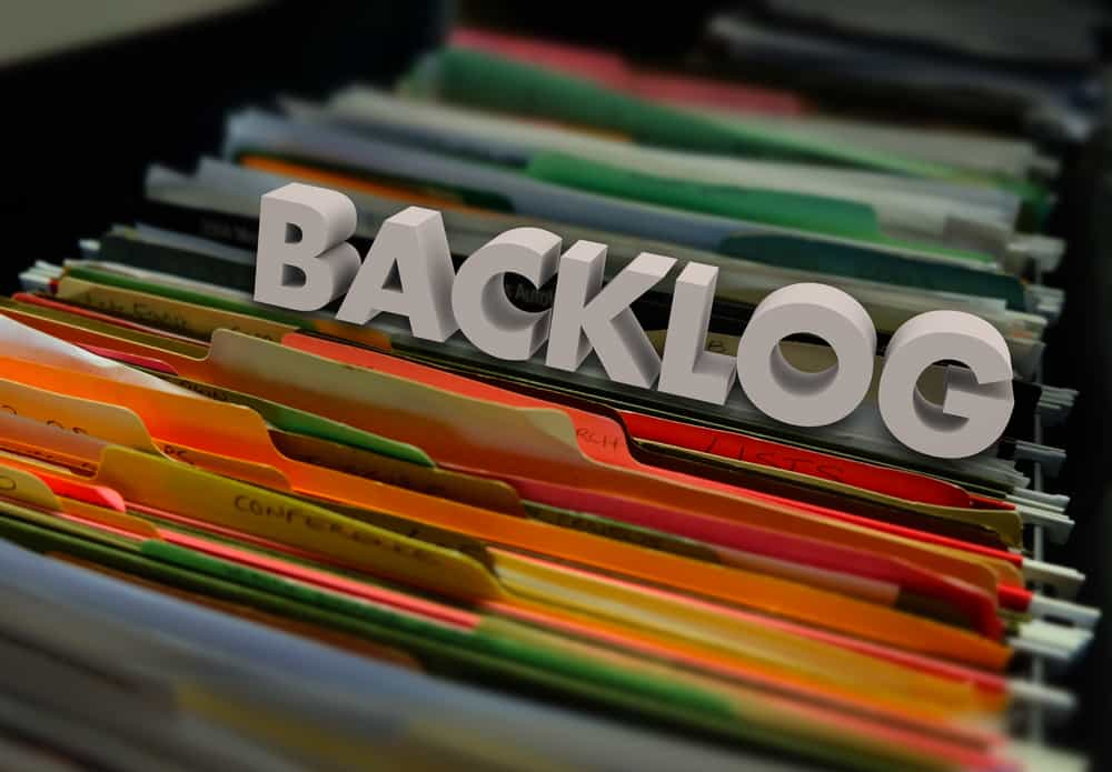 Image of an open draw in a filing cabinet with the word Backlog made from plastic letters on top