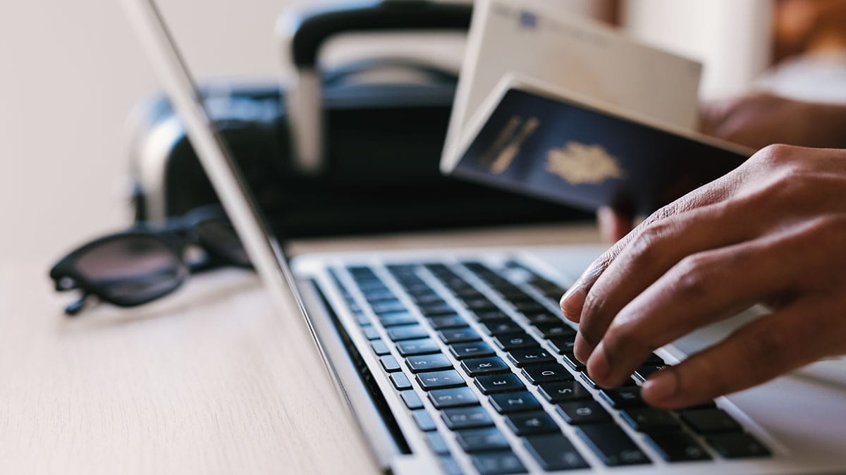 An image of a traveller checking passport details on a laptop