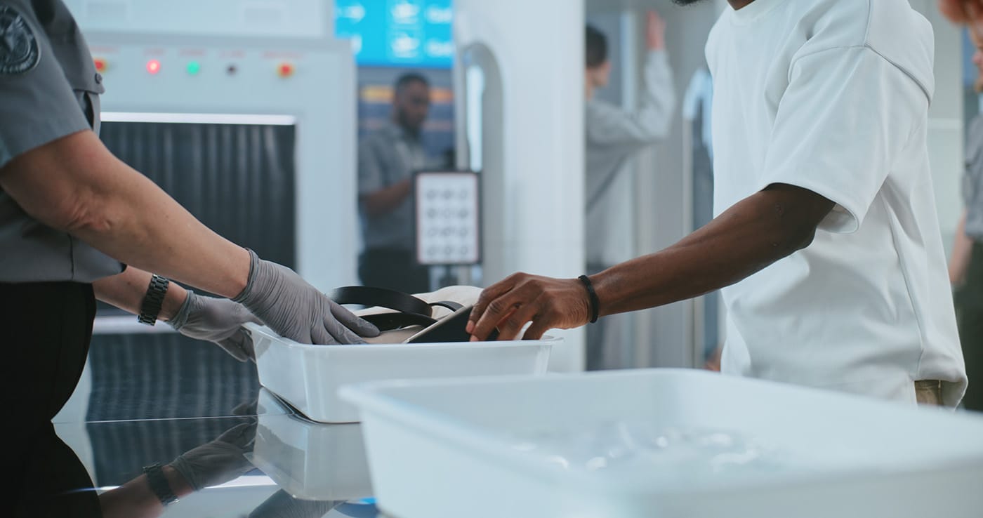 A close up image of a security agent inspecting a traveller's documents at an airport security check