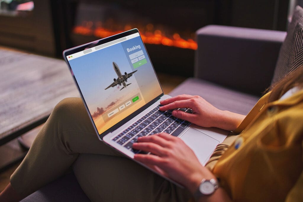 Uma imagem de um homem a utilizar uma agência de viagens online para reservar bilhetes de avião