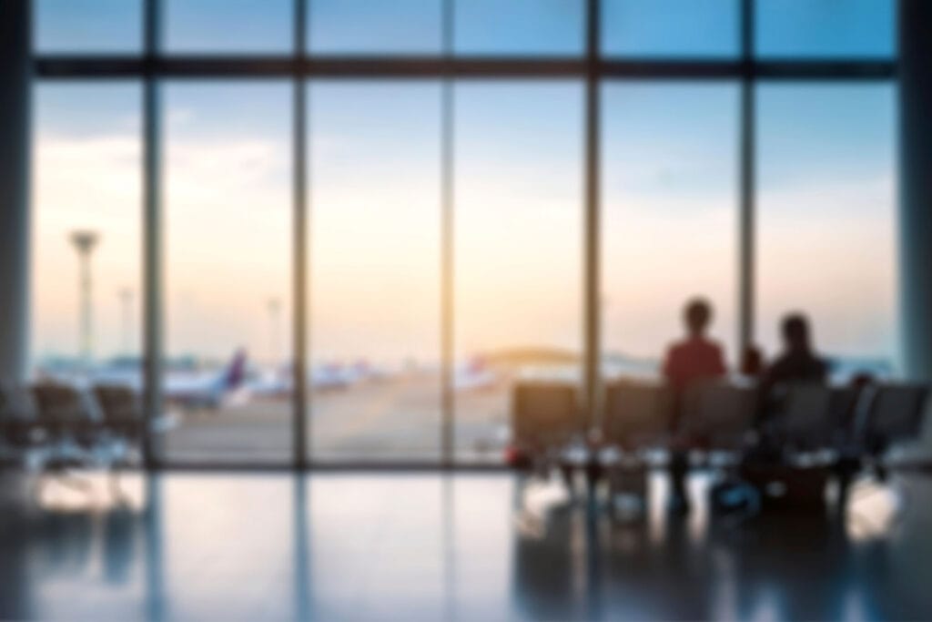 A blurred image of a departure lounge at an airport at sunset