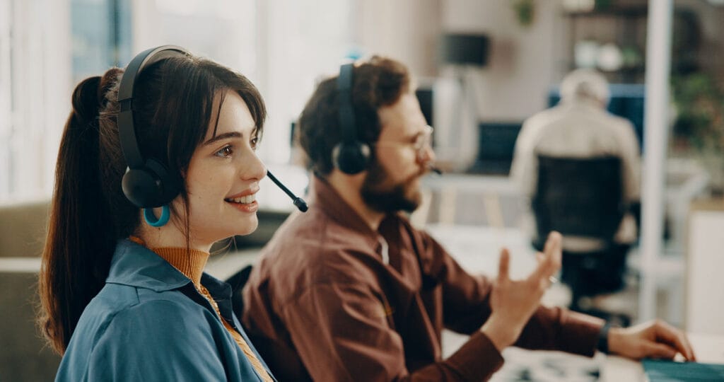 A customer support team wearing headsets conversing with users