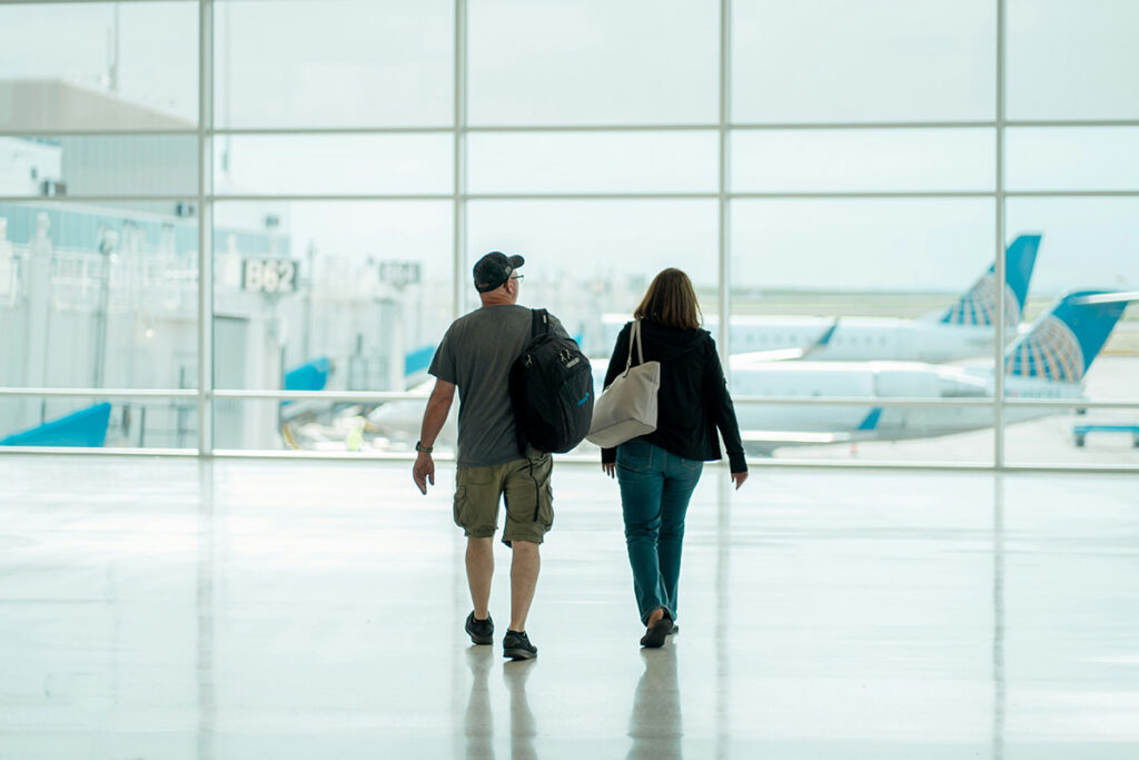 An image of a couple walking to the departure lounge at an airport